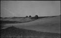 Dune, with three abandoned huts in the distance