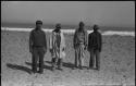 Four men standing on a beach