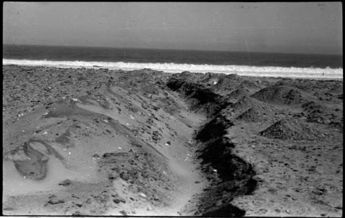 Ditch on shore, with water in background