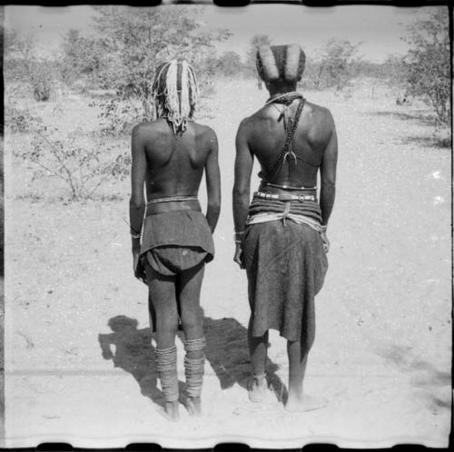 Two women standing, view of their backs