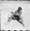 Woman sitting on the ground and playing a musical bow