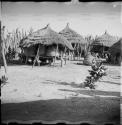 Storage baskets on platforms and covered with thatched roofs, inside kraal