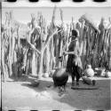 Woman stirring something in a large pottery cooking pot on the fire