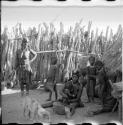 Women and children sitting and standing inside the kraal