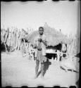 Man standing and holding a musical bow