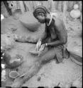 Woman sitting and making a pot