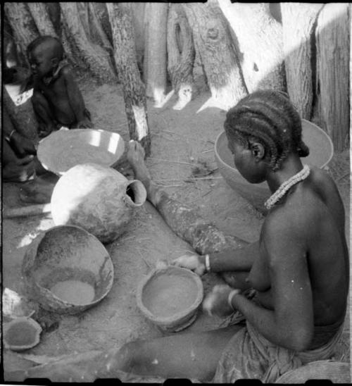 Woman sitting and making a pot