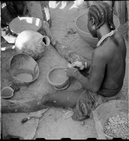 Woman sitting and making a pot