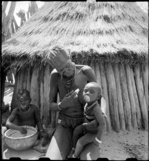 Elderly woman feeding two children