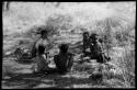 "Old Gau" to the left, two unidentified Ju/'hoan boys, Di!ai, and Gao, father of N!aba, all seated