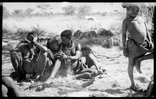 /Naoka, Di!ai's mother, and Di!ai with her two sons, Debe and /Gaishay, seated close together