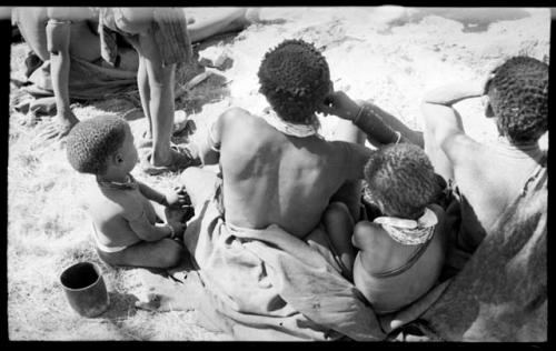 Di!ai and her two sons, Debe and /Gaishay, seen from the back