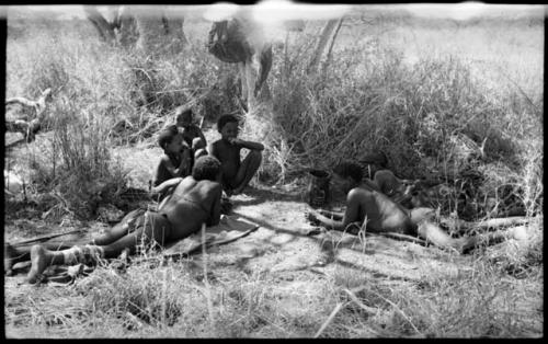 Group lying in the shade mostly likely eating meat including "Old Gau", Tsamgao, "Little ≠Gao", /Gaishay (!U and ≠Toma's son), and two unidentified people