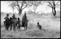 "Little ≠Gao" holding a stick and a group of unidentified Ju/'hoan women and children