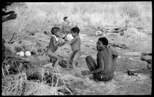 "Gao Medicine", seated, "Little ≠Gao", /Gaishay (Di!ai's and "Gao Medicine's" son), and other unidentified people in the background