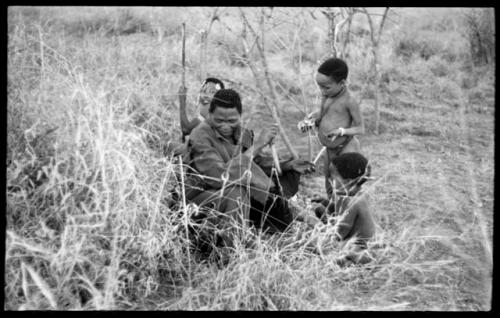 "/Qui Navel" seated with unidentified boys beside him