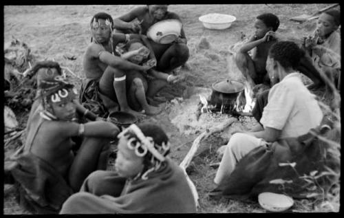 //Kushay, "Little ≠Gao", !Ungka, "Old Gau", and other unidentified people seated around a pot on a fire