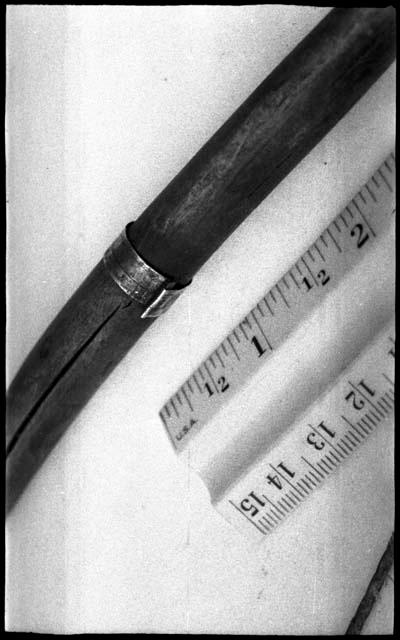 Metal band around bow and ruler for measurement