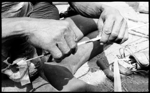 Person's hands fitting shaft to connecting link