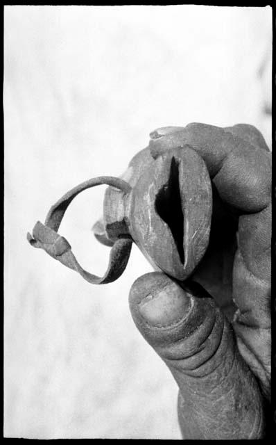 Person's hand holding the end of a knife shaft, showing the opening