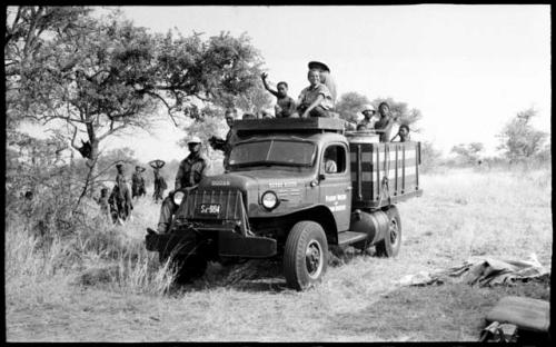 Members of the expedition including Elizabeth Marshall Thomas, Kernel Ledimo, John Marshall, and Robert Story, and Ju/'hoansi on the Dodge power wagon