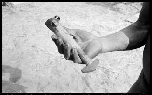 Person's hand holding a knife in its shaft