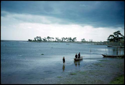 People and boats along shore