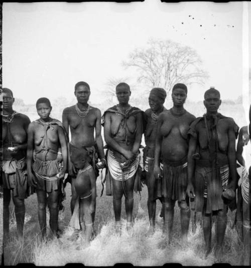 Women standing in a circle, and clapping, singing and taking turns dancing