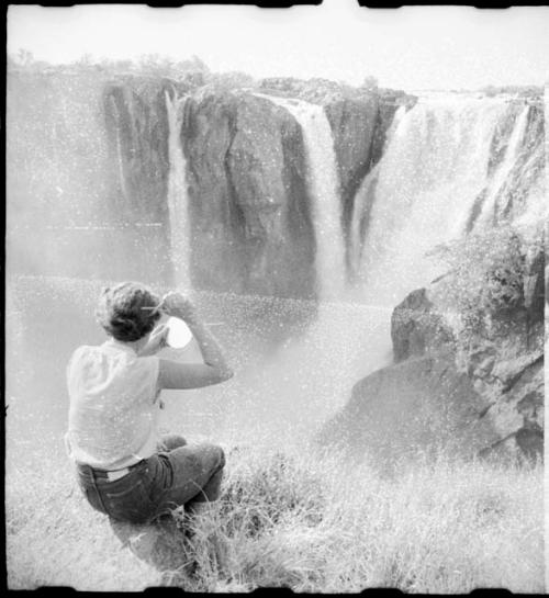 Elizabeth Marshall Thomas cutting her hair in front of the main jet of Ruacana Falls