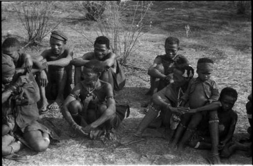 /Qui (brother of "Gao Helmet," "/Qui Navel," and "Old ≠Toma" sitting in back row; /Gasa, unidentified woman (possibly !U's mother Naoka), Khuan//a (wife of Gau) with Qui (her son), and !Naishi (son of "/Qui Navel" and //Kushay) sitting in front row