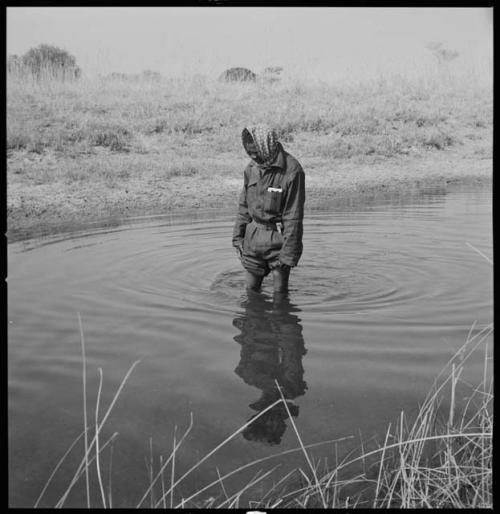 Kernel Ledimo standing in the Muzwamo River with his trousers pulled up