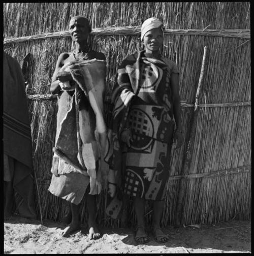 Two women standing in front of a fence