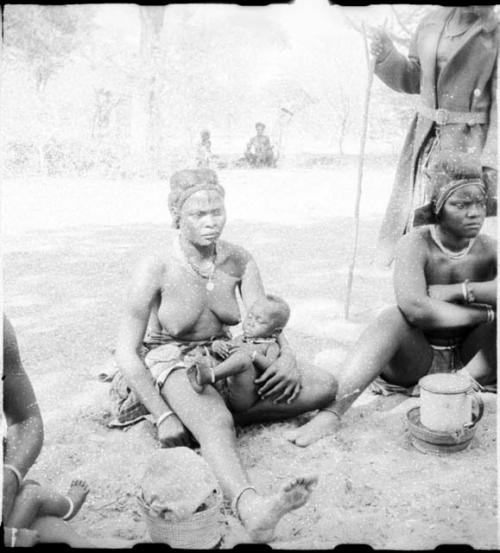 Women sitting, and one is holding a baby