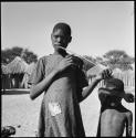 Ditiho playing the le-!goma, and a boy standing next to her