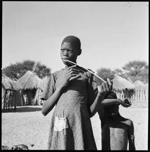 Ditiho playing the le-!goma, and a boy standing next to her