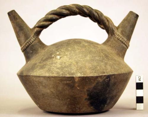 Black pottery vessel, with 2 spouts and stirrup handle