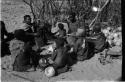 Group at Chukudu sitting; child drinking tsama melon juice