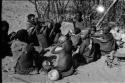 Group at Chukudu sitting; child drinking tsama melon juice