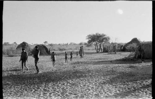 Group walking in the Chukudu village in the space between huts