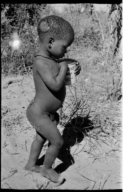 Child walking holding a can