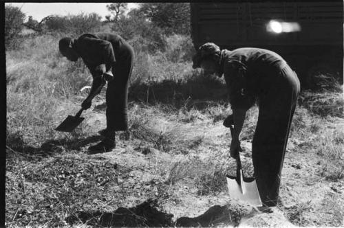 Two expedition members clearing the ground with shovels