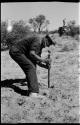 Expedition member digging into the ground with a shovel