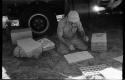 Robert Story kneeling by truck with plant specimens