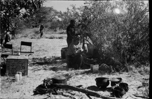 Camp scene, three expedition members in background