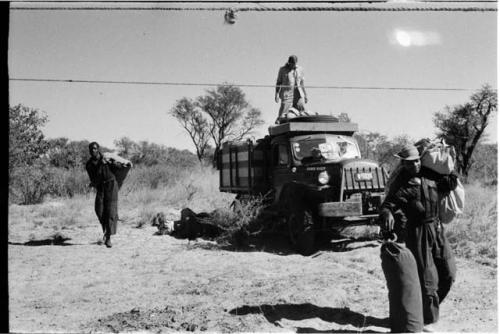 Bill Donnellan on truck throwing things down; Kernel Ledimo and Philip Hameva carrying items