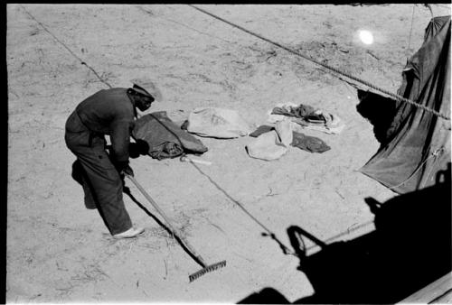 Kernel Ledimo raking the place where Lorna Marshall's tent was to be set