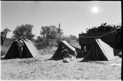 Casper Kruger and another expedition member setting up tents; three tents in front of expedition truck