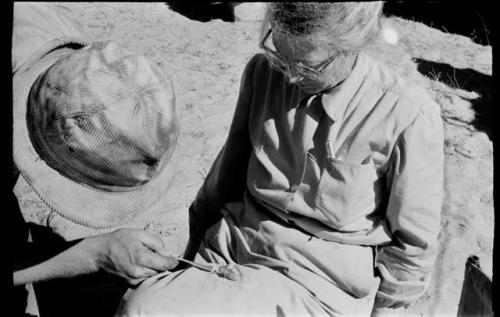 Lorna Marshall with a grasshopper in her lap; Casper Kruger feeding the grasshopper