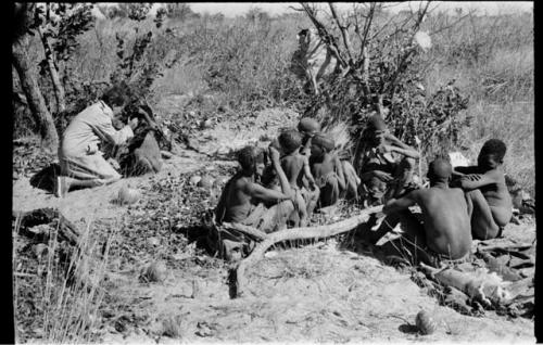 Elizabeth Marshall Thomas putting ointment into a child's eye; others watching