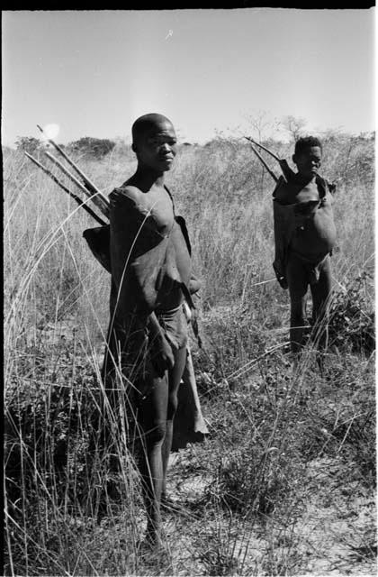 Oukwane and !Gai standing with their hunting equipment